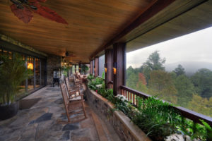 Covered porch with stone floors, wood ceilings, and long range mountain views