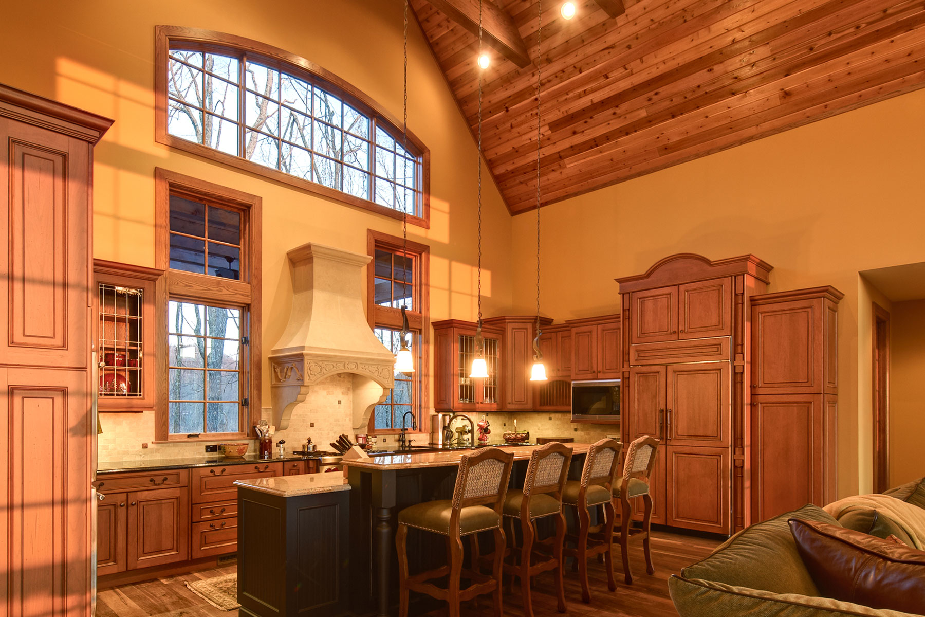 ACM Design created this beautiful mountain kitchen with wood cabinets, center island with bar, wood clad vaulted ceilings for clients in WNC.