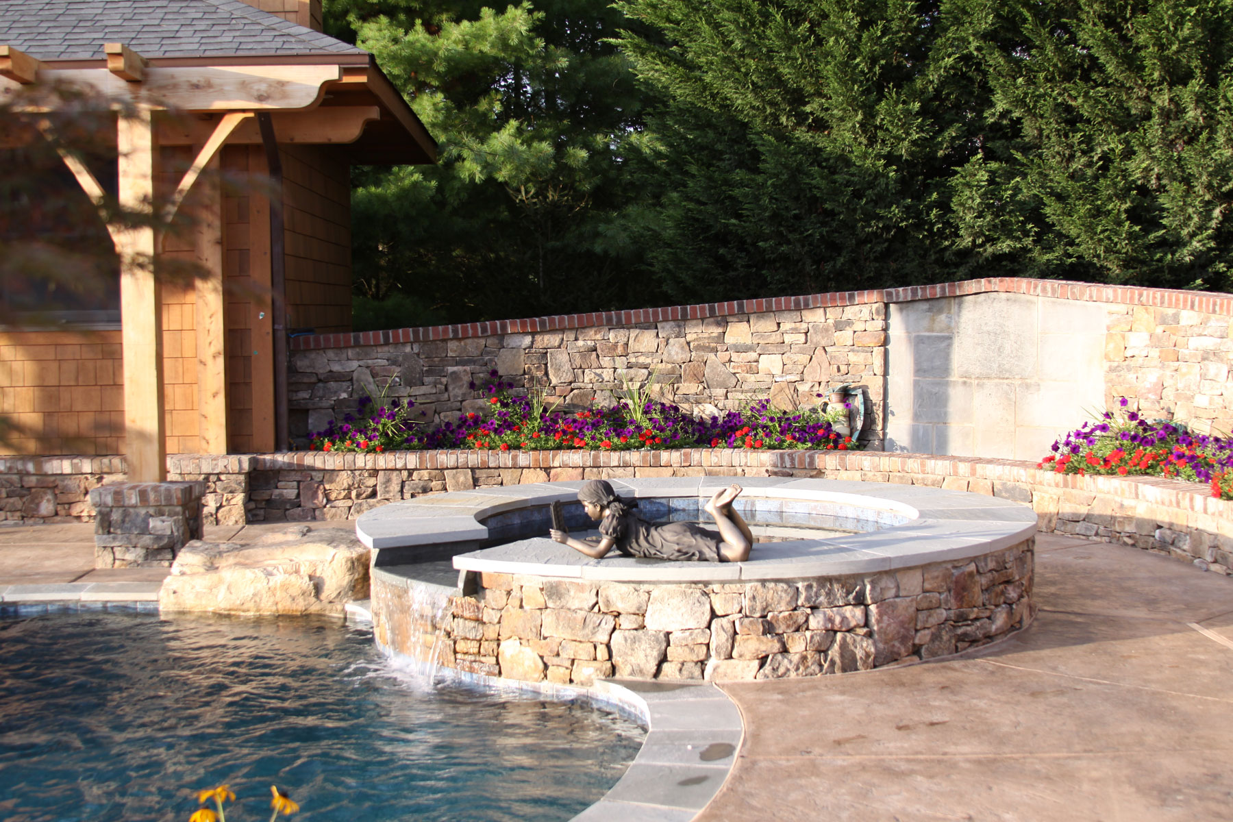 Sculpture on spa ledge opening to pool