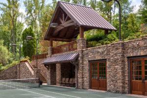 Tennis court pavilion made with timber and stone for courtside viewing