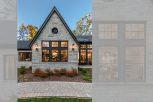 Large front windows with black frames on stone-clad house