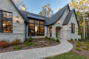 Front entry and walkway to white stone and brick mountain home