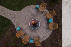 Mountain home firepit with cobblestone pavers in circular pattern with walkway