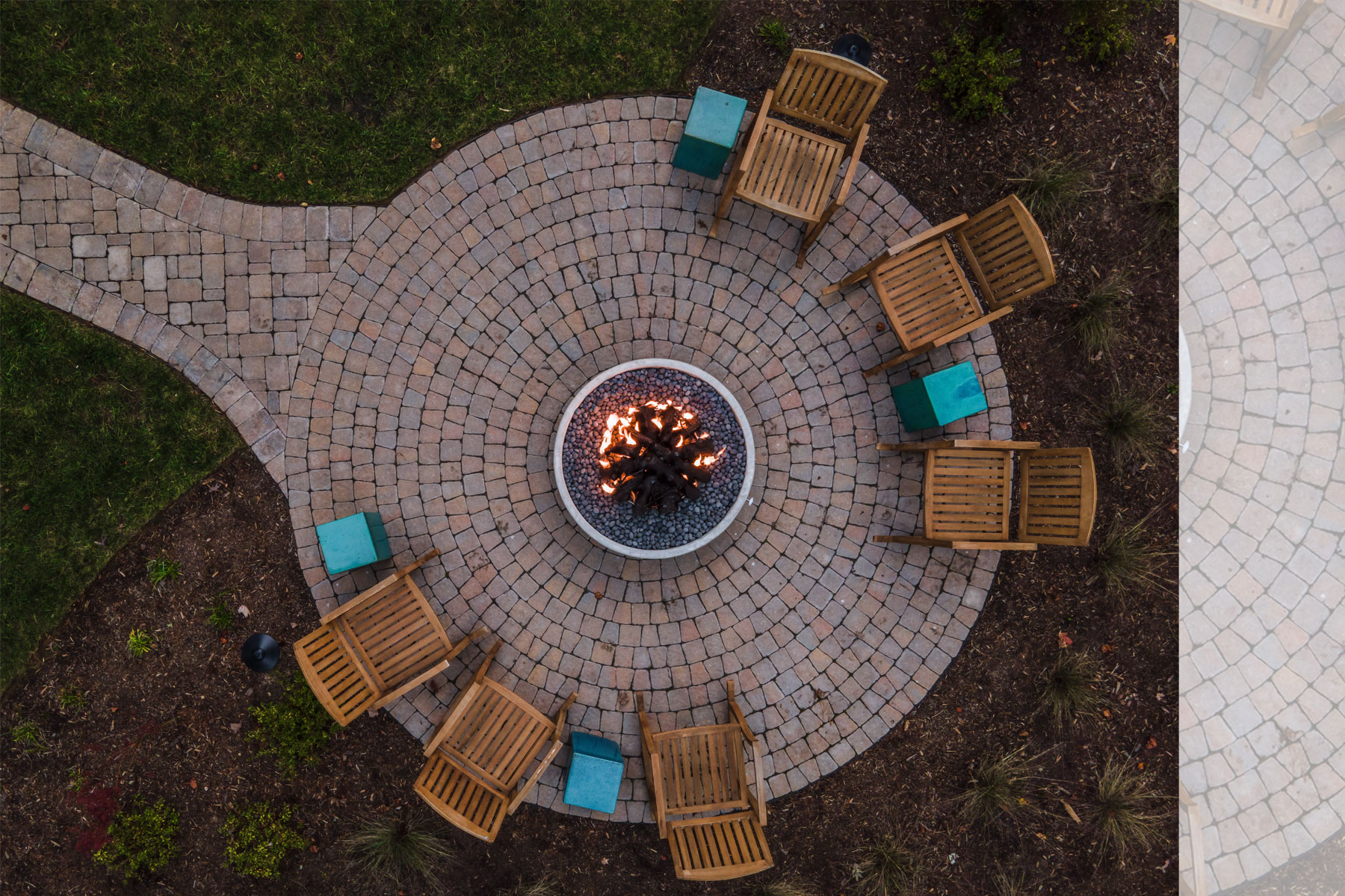 Mountain home firepit with cobblestone pavers in circular pattern with walkway