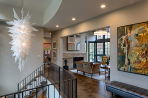 Interior entryway of mountain home with unique light fixture in 2-story foyer to lower level