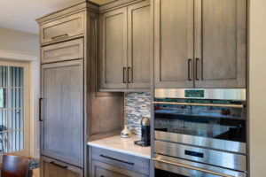 Appliance wall in new modern, rustic kitch with gray cabinets