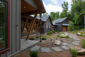 Front porch entry of modern style mountain home with wood beam architectural elements