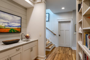 Lower level wet bar with bookcases separting to TV room