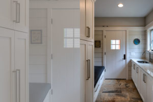 Side entry mudroom through breezeway with laundry and dropzone