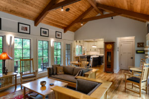 Living room to kitchen view in new mountain craftsman with vaulted, wood clad ceiling