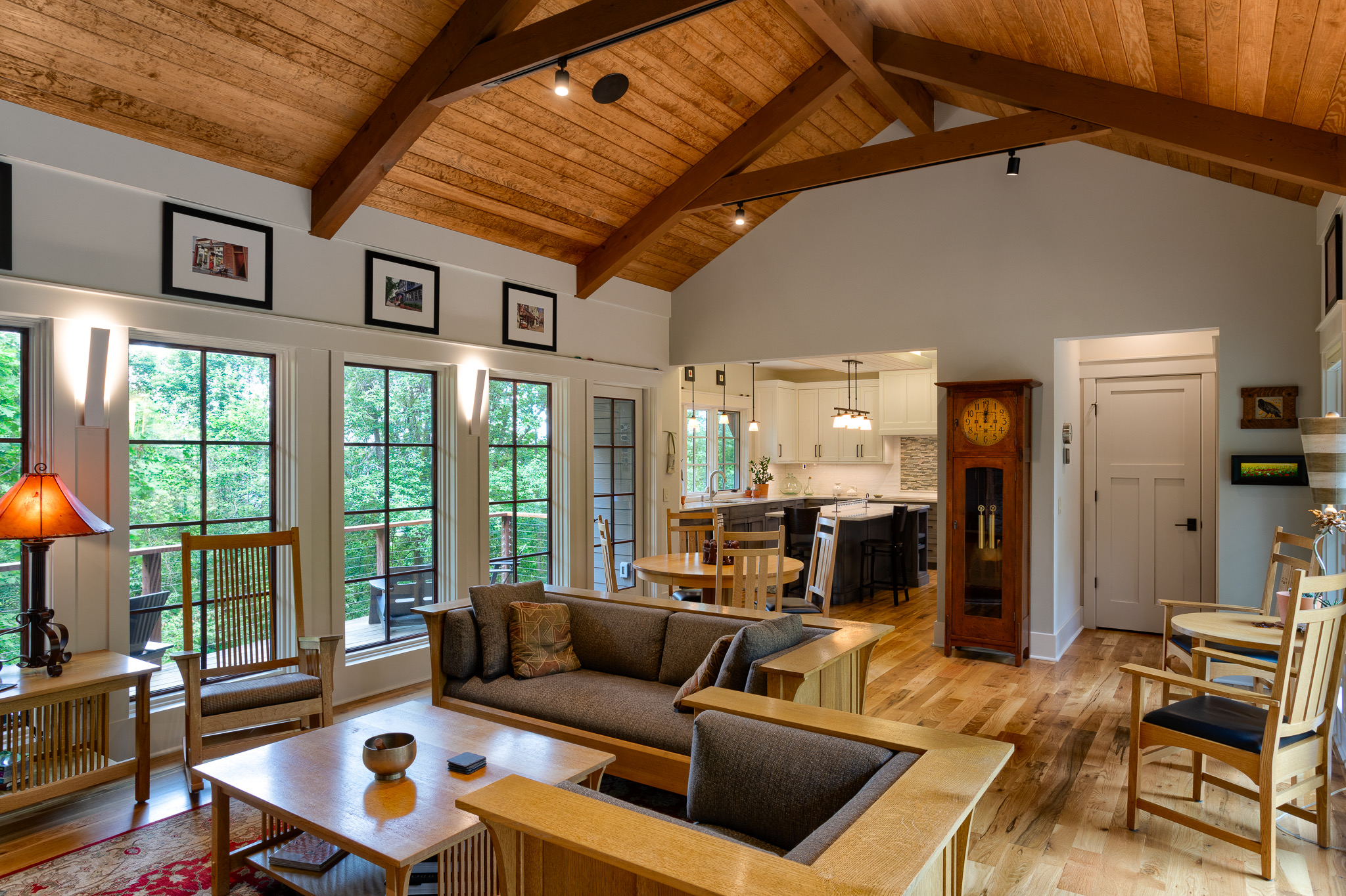 Living room to kitchen view in new mountain craftsman with vaulted, wood clad ceiling