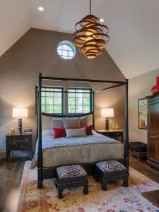 Master bedroom with vaulted ceilings, windows behind bed, canopy bed