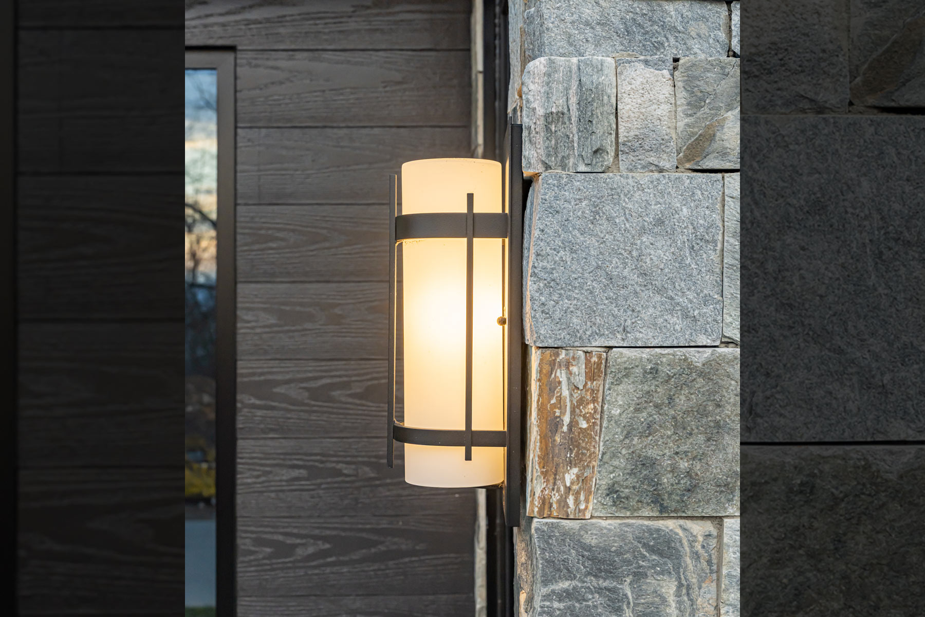 Rustic mountain charm of exterior light fixture against stacked stone