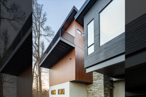 Exterior material choices for modern mountain home: wood (black and medium-stained), stucco, rock