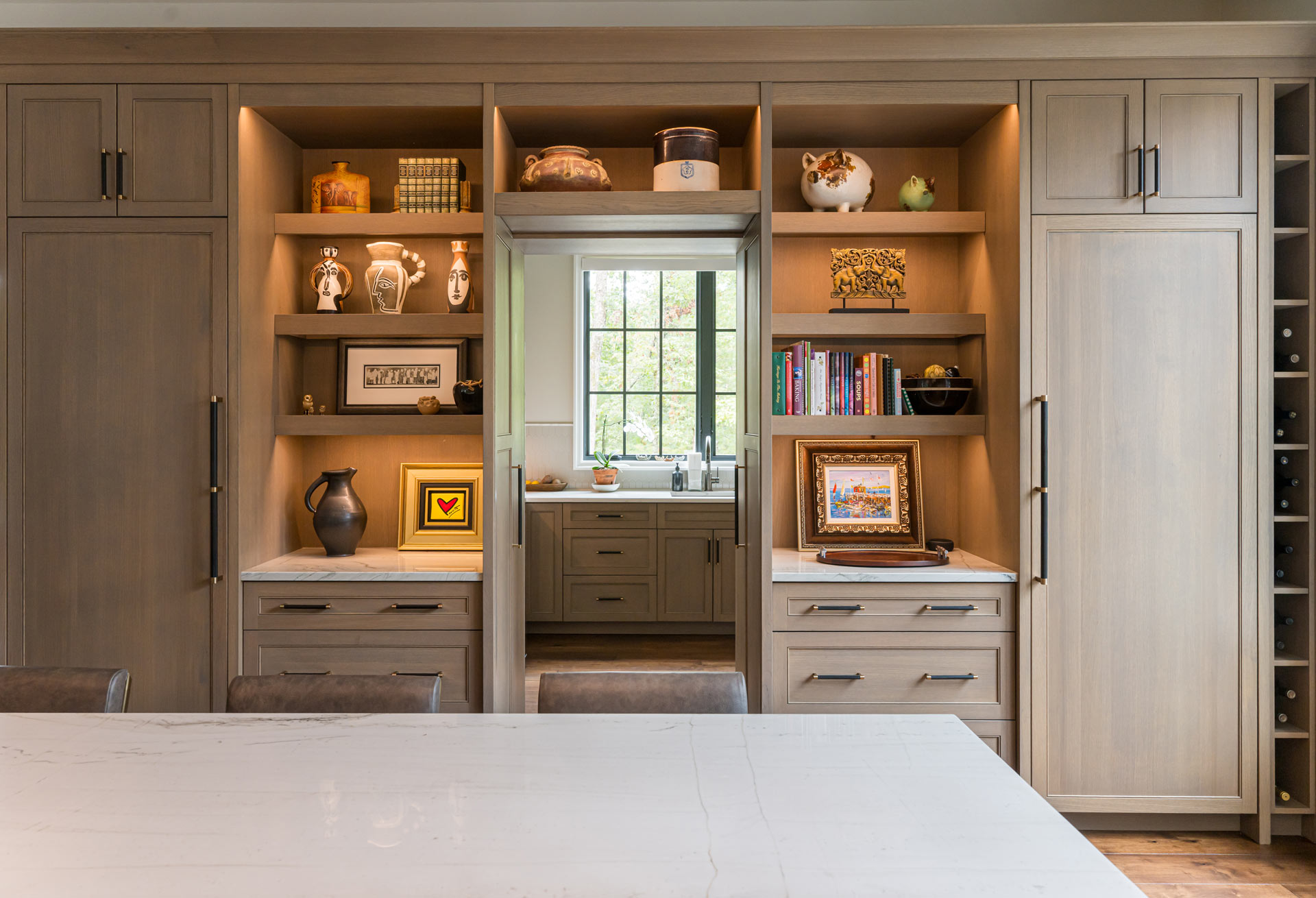 wall-cabinetry-concealing-pantry-entry-flanked-fridge-freezer